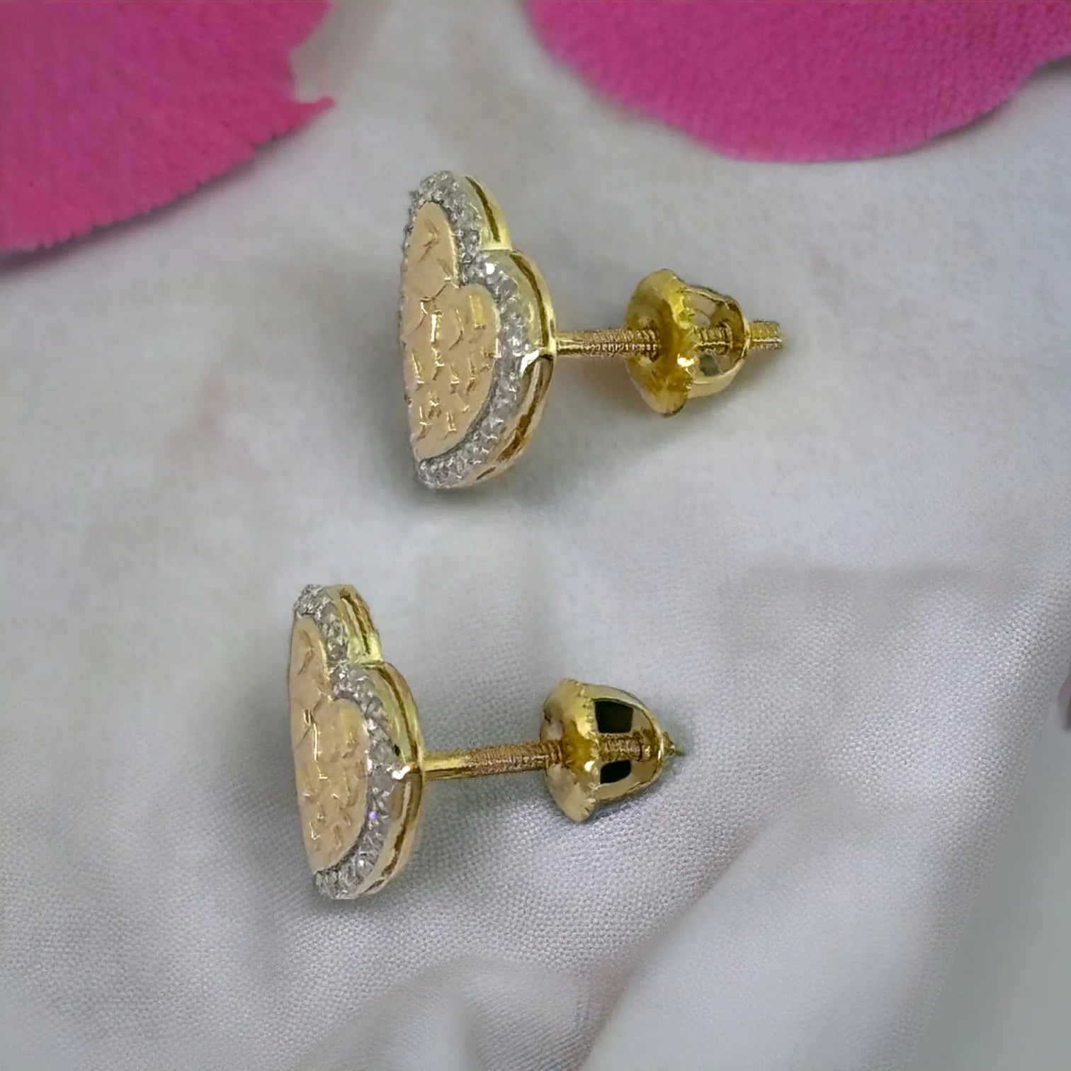 Side and back view of 10KT gold 10mm heart diamond stud earrings (0.15ct SI clarity), highlighting secure screw-back posts and polished finish on white fabric
