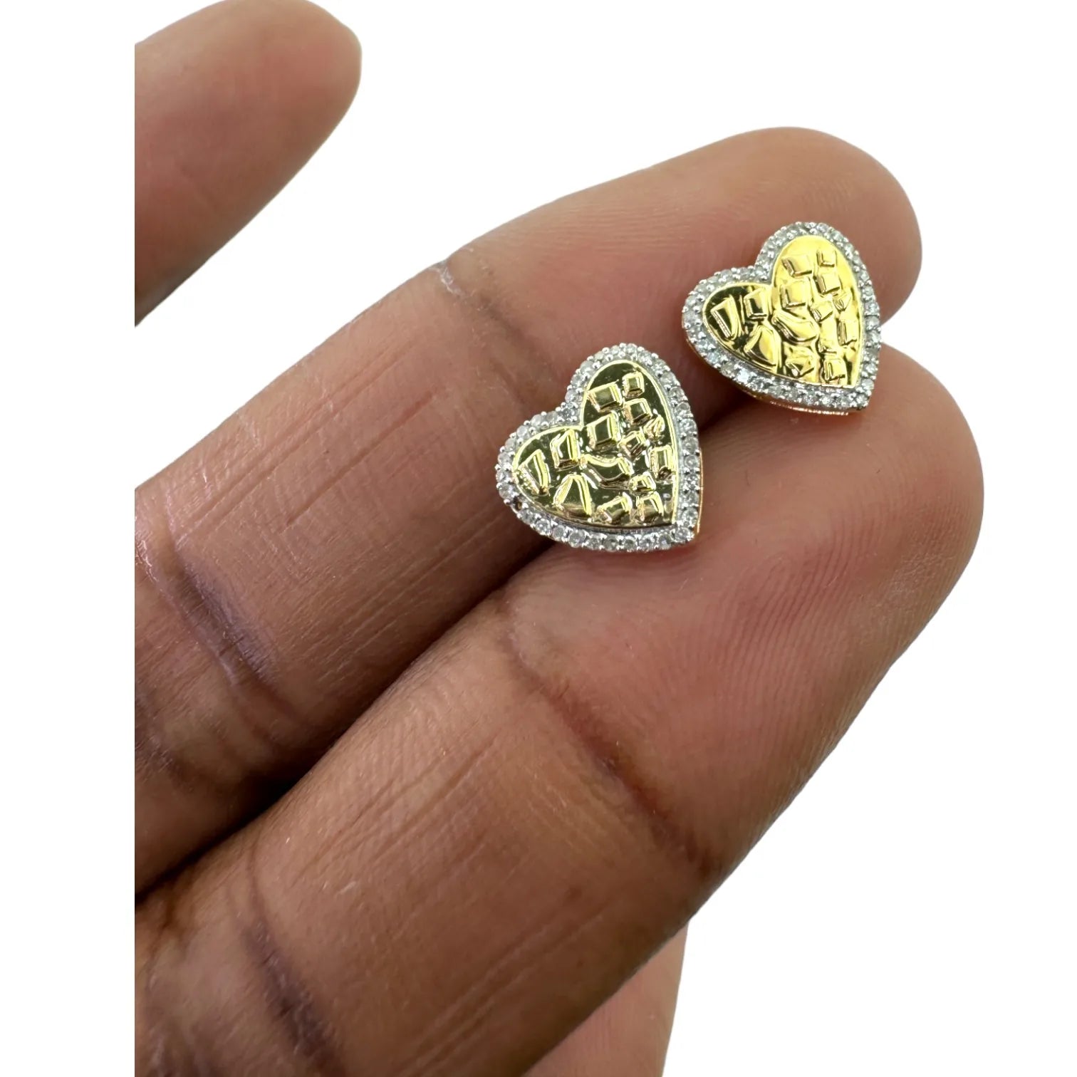 10KT yellow gold 10mm heart stud earrings with 0.15ct total genuine SI diamonds, held in hand to show real size and textured gold nugget center with diamond halo border