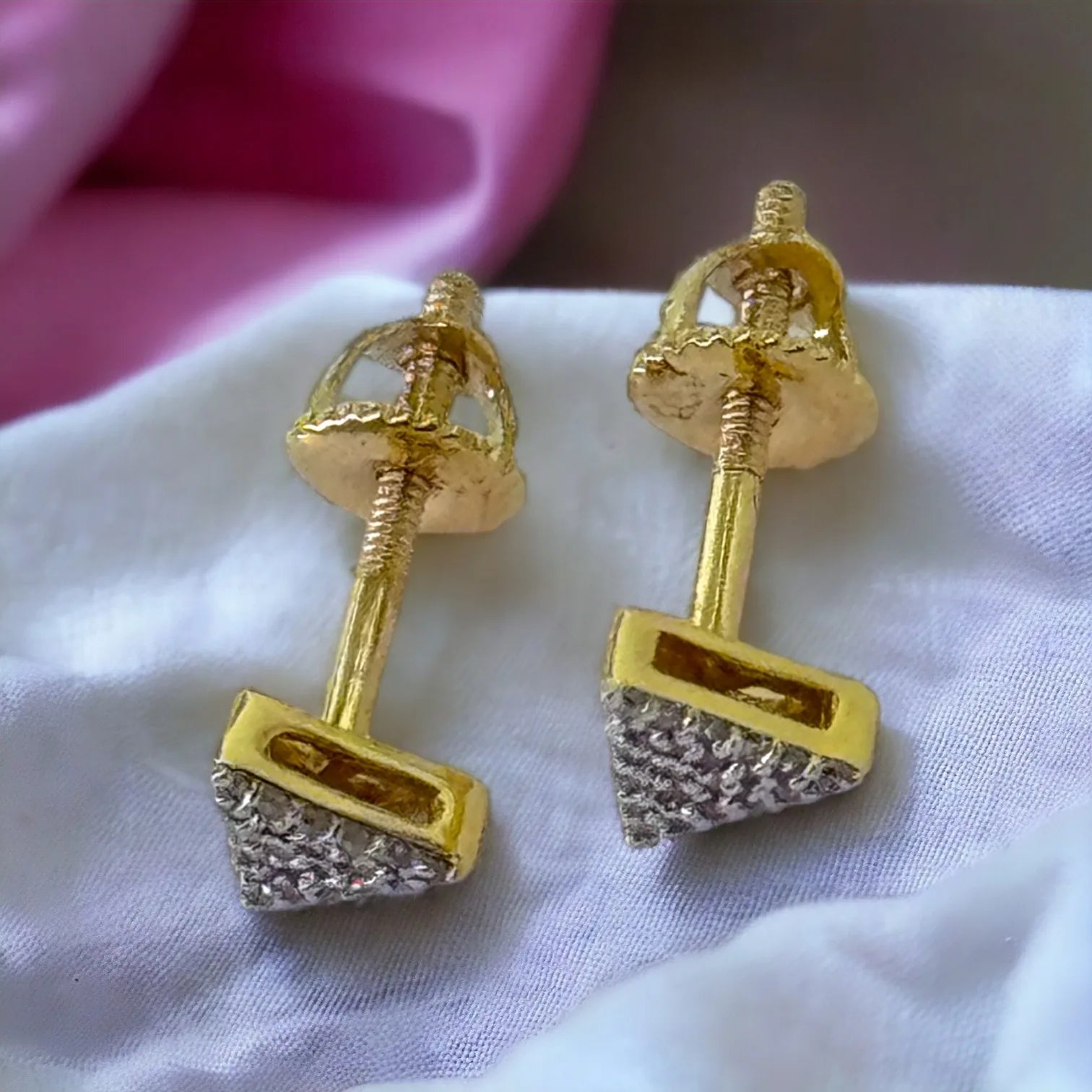 Angled view of tiny 10KT gold triangle stud earrings with 0.09ct genuine SI diamonds, emphasizing sharp geometric design and polished edges