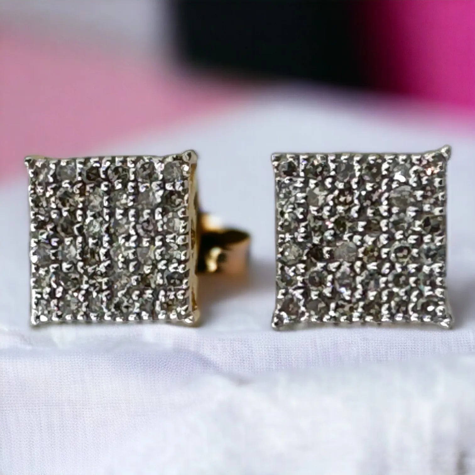 Pair of 10KT yellow gold 6mm square pave diamond stud earrings featuring 0.28ct total genuine SI diamonds, front view showcasing full sparkle on clean white surface with pink background