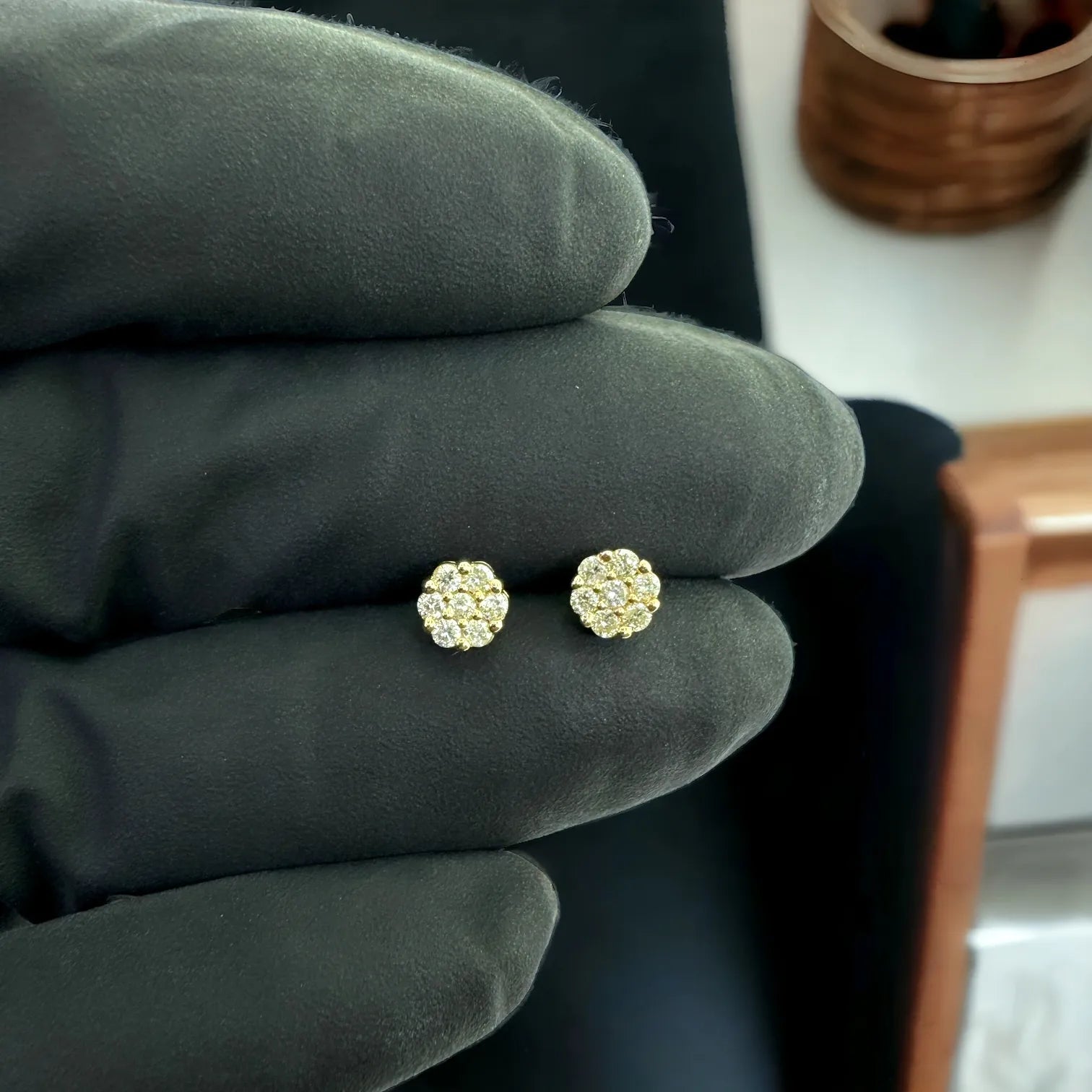 10KT yellow gold 0.25ctw SI diamond flower studs held in gloved hand, 5mm floral cluster earrings with secure screw-back posts