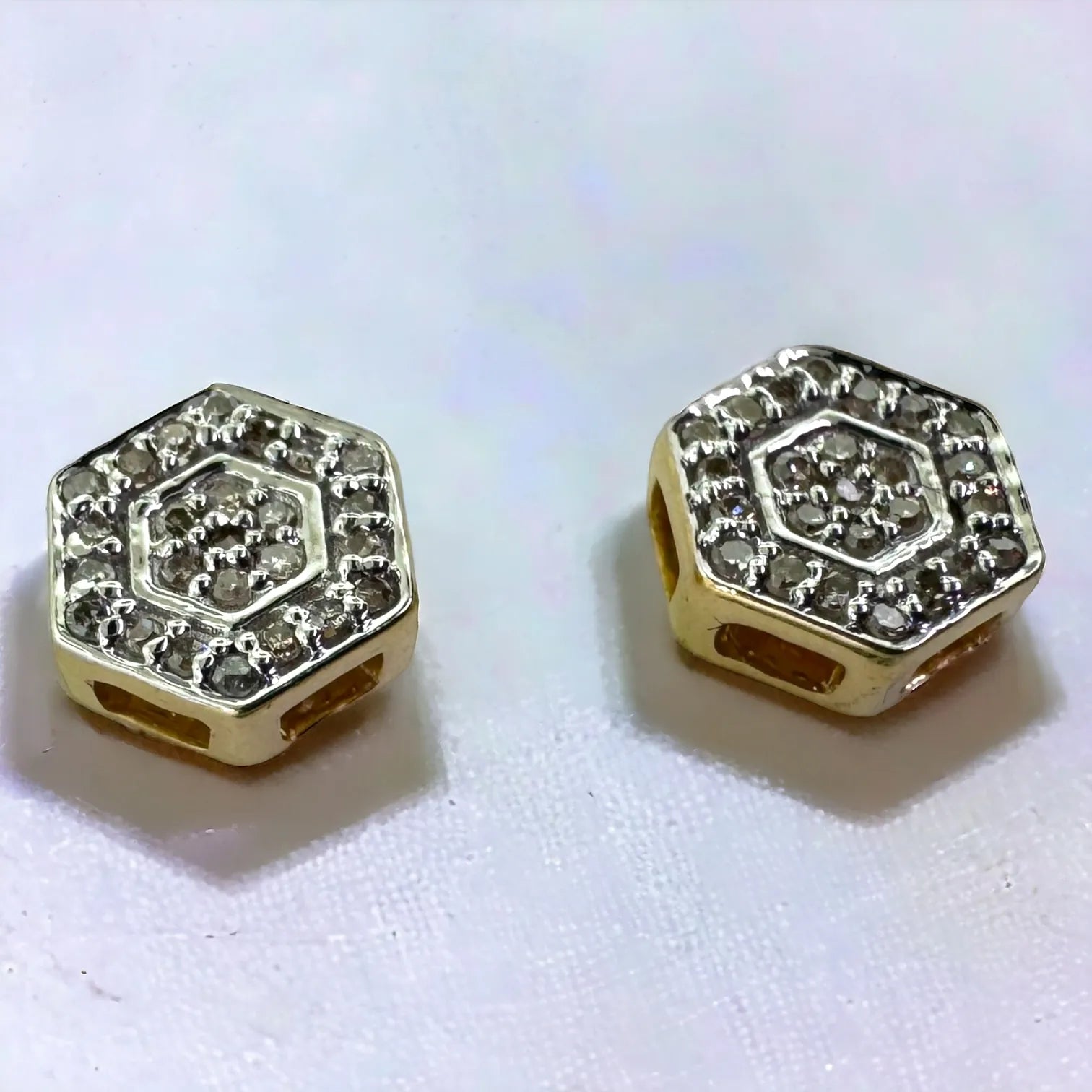 Side and angled view of 10KT yellow gold hexagon earrings highlighting the sparkling pave diamond setting and polished screw-back mechanism