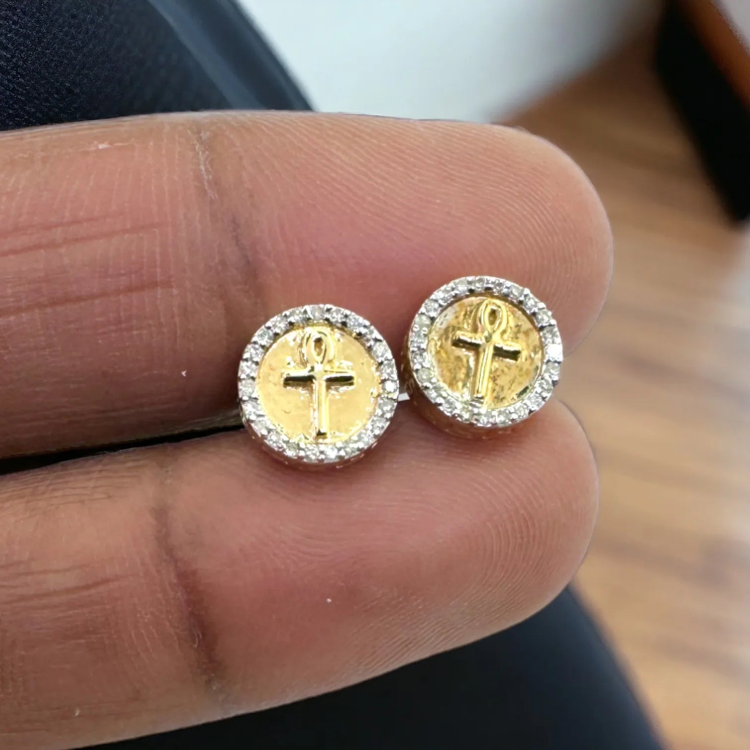 10KT gold 9mm Ankh cross diamond stud earrings (0.15ct SI clarity) held in hand to display actual size and bold Egyptian cross symbol surrounded by sparkling pave diamonds