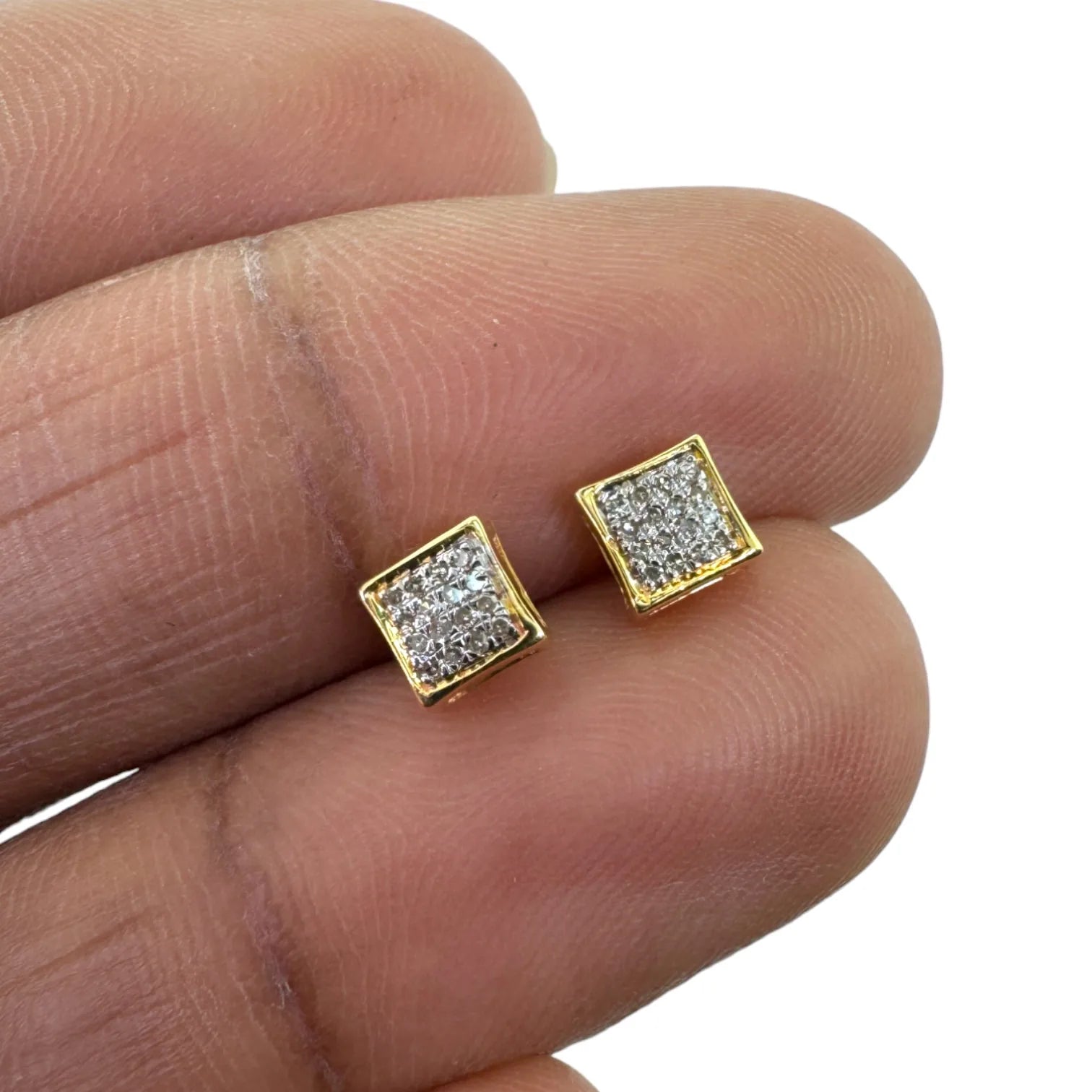 Tiny 10KT yellow gold 5mm square pave diamond stud earrings (0.09ct total SI diamonds) held delicately in hand to show petite size and intense sparkle