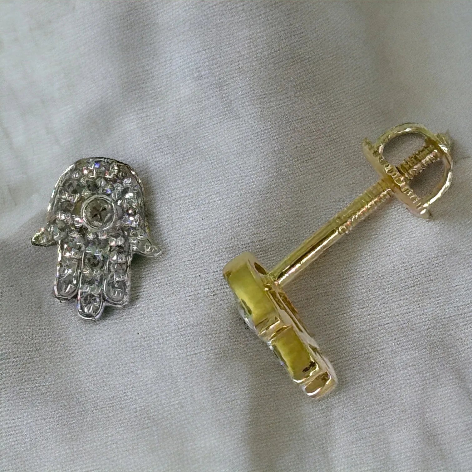 Close-up of 10KT yellow gold Hamsa diamond stud 0.12ctw SI, evil-eye center detail with screw-back and butterfly closure