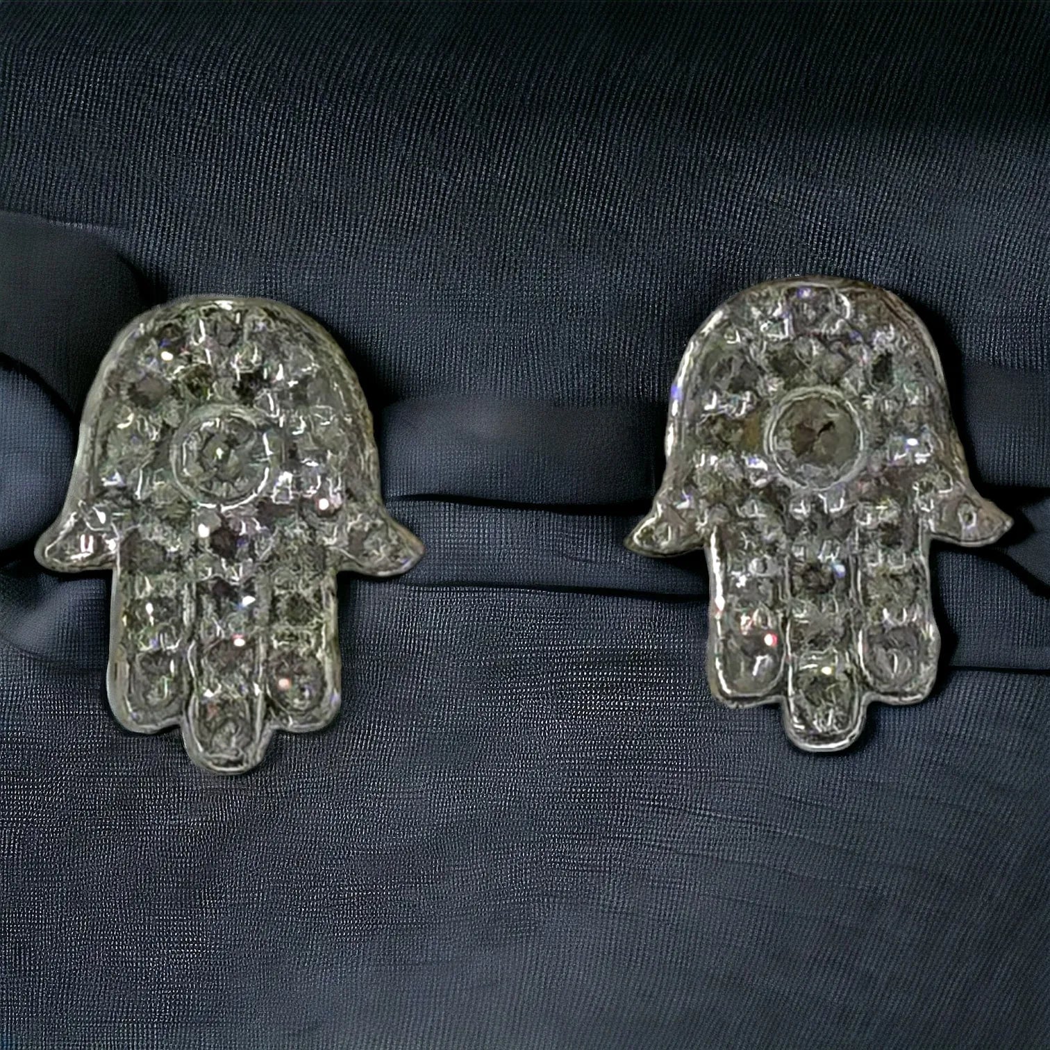 Back view of 10K yellow gold diamond Hamsa hand earrings 0.12ct total weight SI clarity, displayed on black fabric showing full pave setting