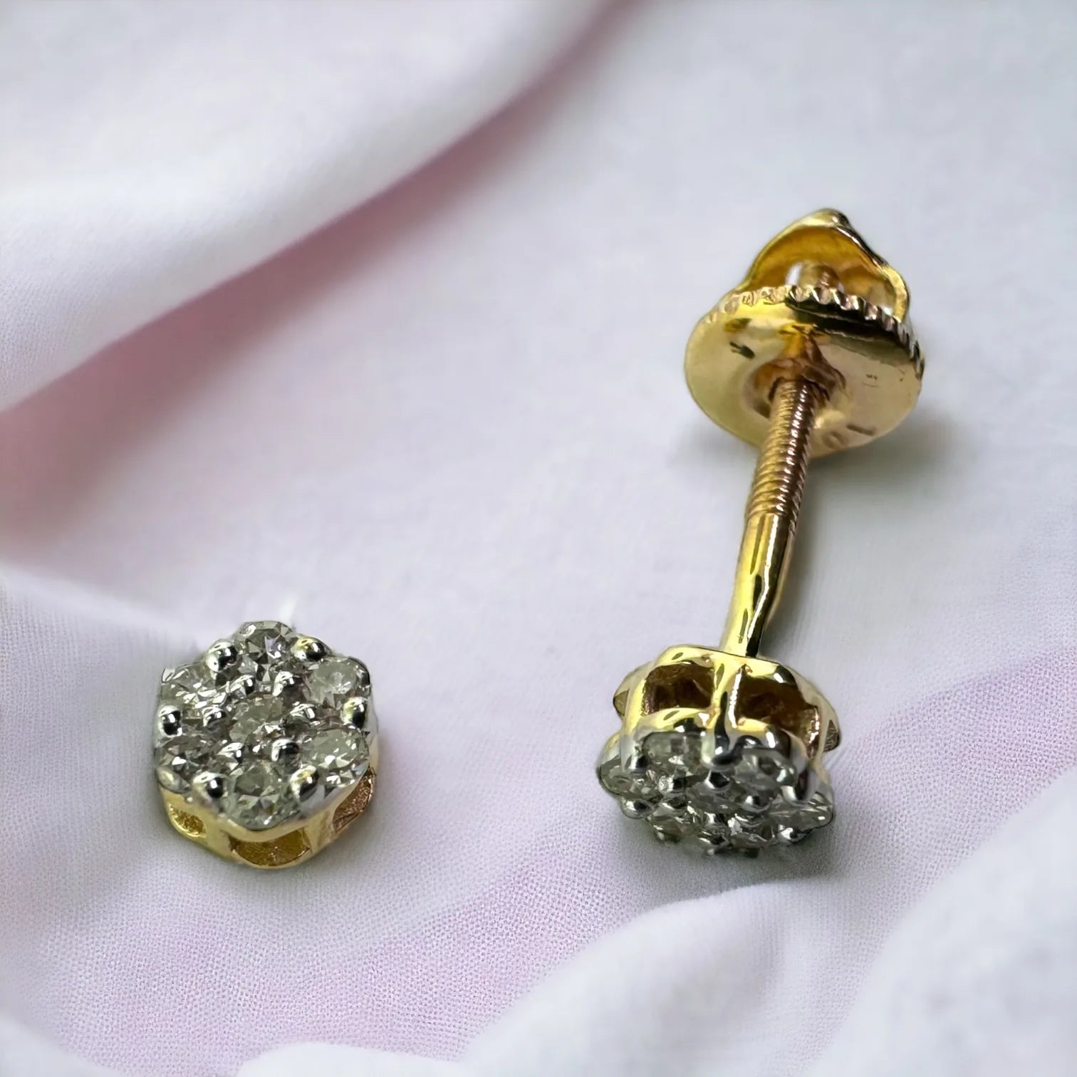 Luxury 10KT yellow gold mini flower stud earrings totaling 0.10ct SI diamonds displayed against dark velvet to emphasize dainty floral design and fire and brilliance